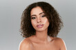 © AS/peopleimages.com - Her skin glows from looking after it. Studio shot of a beautiful young woman posing against a gray background.