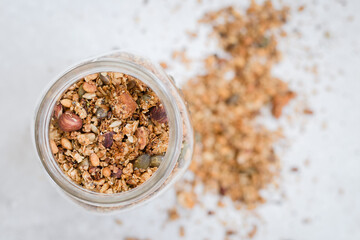 Wall Mural - Glass jar of yummy healthy granola in the blurred background