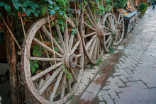 Closeup Shot Of Wooden Wagon Wheels  On The Side Of A Pathway In A Park