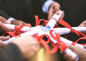 Leinwandbilder - When it comes to education, go all in. Shot of a group of students holding their diplomas together on graduation day.