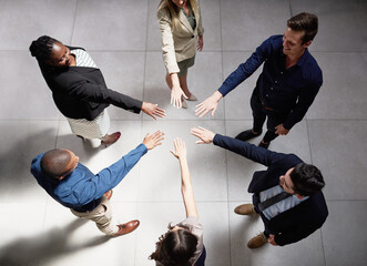 Wall Mural - Reaching for greatness together. High angle shot of a group of businesspeople joining their hands together in unity.