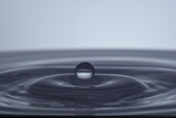 Fototapeta Łazienka - Kropla nad taflą wody na jasnym tle