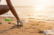 © sorapop - Volunteer woman picking plastic bottle into trash plastic bag black for cleaning the beach, female clean up garbage, Ecology concept and World Environment Day, Save earth concept