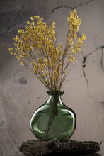 Vertical Of A Decorative Vase With Dried Yellow Flowers Against The Cracked Wall Background