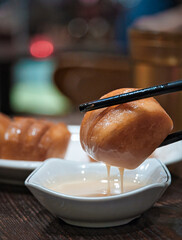 Sticker - Vertical shot of deep fried steamed bun with chopsticks.