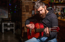 Live Music. Guitars And Strings. Bearded Man Playing Guitar, Holding An Acoustic Guitar In His Hands. Music Concept. Bearded Guitarist Plays. Play The Guitar. Beard Hipster Man Sitting In A Pub