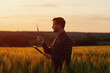 © eduard - Man agronomist farmer with folder standing on wheat field and checks the quality of harvest. Farm worker looking at grain spikelet. Agriculture, business and rural concept.