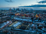 Fototapeta Miasto - Widok na zamek królewki i stare miasto w Warszawie z drona, w tle wieżowce, zaśnieżone dachy, zachód słońca
