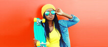 Portrait Of Young African Woman With Skateboard Wearing Sunglasses, Hat In Casual On Vivid Background, Blank Copy Space For Advertising Text