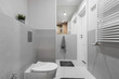Jasna łazienka w odcieniach szarości i materiałąch drewnopodobnych