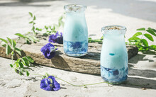 Butterfly Pea Blue Tea Latte, Served In A Jar. Topping With White Milk Froth And Fresh Butterfly Pea Petals