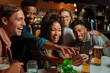 © Prins Productions - Group of young adult friends taking selfies at dinner sitting in restaurant