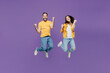 © ViDi Studio - Full body overjoyed excited young couple two friends family man woman together wearn yellow casual clothes jump high do winner gesture clench fist isolated on plain violet background studio portrait.