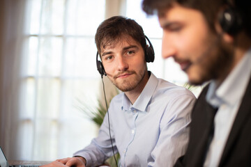 Wall Mural - télé conseillers, employés de bureau ou hommes d'affaires qui travaillent au bureau. Ils ont un micro casque pour participer a une réunion à distance ou répondre au téléphone