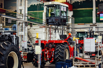 Wall Mural - Industrial workers assembles agricultural tractor in workshop