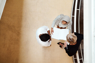 Aufkleber - Ensuring they remain on the same page. High angle shot of a group of businesspeople having a discussion while going through paperwork together in an office.