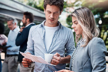 Wall Mural - What are your thoughts on the latest reports. Shot of two businesspeople going through paperwork together outdoors.