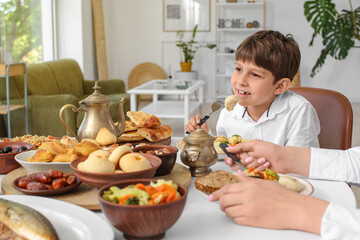 Wall Mural - Muslim little boy having breakfast. Celebration of Eid al-Fitr