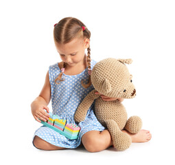 Sticker - Cute little girl with building blocks and teddy bear on white background