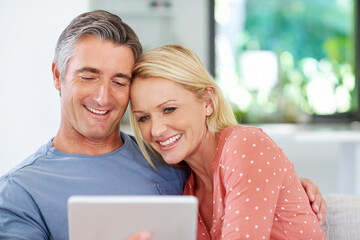 Poster - Relaxing together with some online entertainment. Shot of a mature couple relaxing with their digital tablet at home.