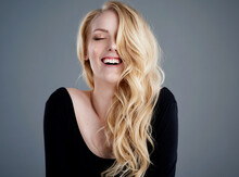 Never Mind Good Hair Day, Have An Awesome Hair Day. Studio Portrait Of An Attractive Young Woman With Beautiful Long Blonde Hair Laughing Against A Gray Background.