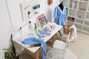 Poster - Interior of stylish atelier with tailor's workplace, mannequin and pegboard