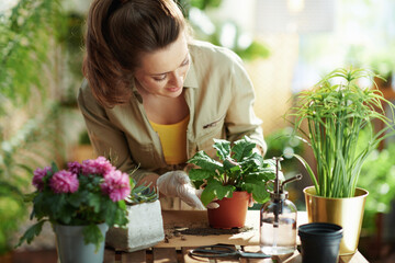 happy female in rubber gloves in sunny day do gardening