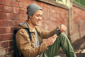 Poster - Lets see whos free to hang out. Cropped shot of a young man texting on his cellphone while out in the city.
