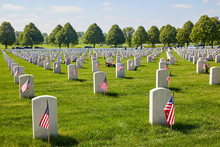 Graveyard Of Fallen Soldiers With American Flags On All Of The White Grave Stones