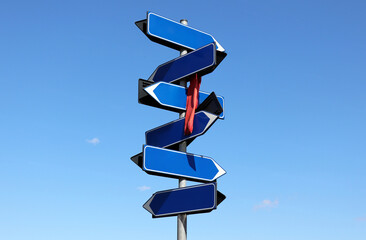 Blank directional road sign on blue sky background.