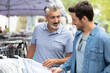 © auremar - men choosing clothes on the market