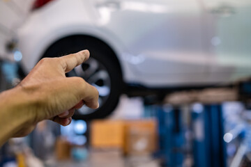 BANGSAEN THAILAND MAR 2022 This car mazda 2 brand japan waiting for repair on car Lift in garage dealership on room customer parked in showroom of thailand for Illustrative editorial image.