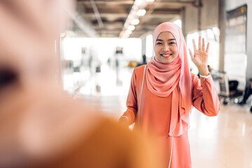 Wall Mural - Two young friend beauty islamic asian arabic muslim woman wearing a hijab enjoying and having fun talking together waving hi and saying hello in the shop at fashion store