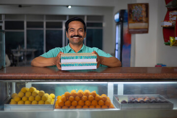 Wall Mural - Sweet shop owner selling sweet to customer