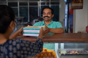 Wall Mural - Sweet shop owner selling sweet to customer