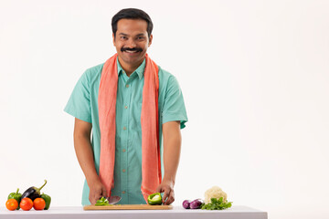 Wall Mural - Portrait of cook servant chopping capsicum with knife in kitchen
