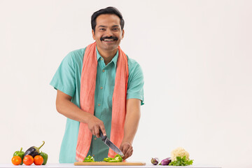 Wall Mural - Portrait of cook servant chopping capsicum with knife in kitchen