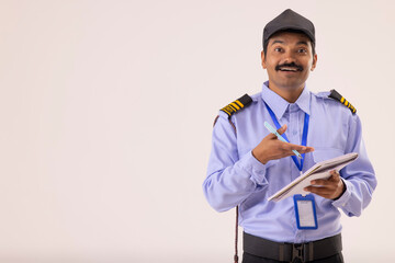 Wall Mural - Portrait of security guard pointing at notebook