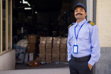 Portrait Of A Male Security Guard With Hands In Pockets While Working In Warehouse