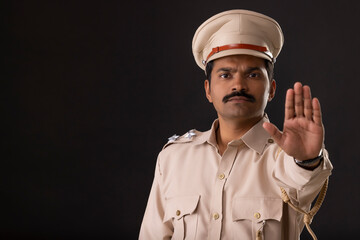Wall Mural - Close-up portrait of an Indian policeman gesturing with palm