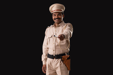 Wall Mural - Portrait of an Indian policeman pointing with baton