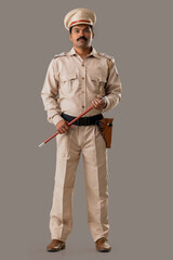 Wall Mural - Portrait of an Indian policeman standing with baton