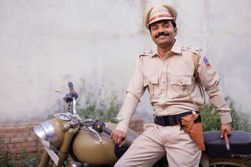 Wall Mural - Portrait of an Indian policeman posing with bike