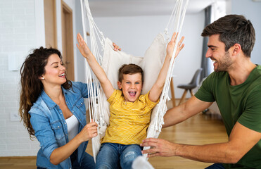 Wall Mural - Young happy family having fun, playing together at home