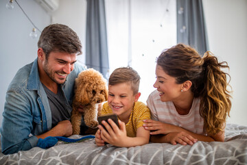 Wall Mural - Happy family with modern devices and dog having fun, playing at home