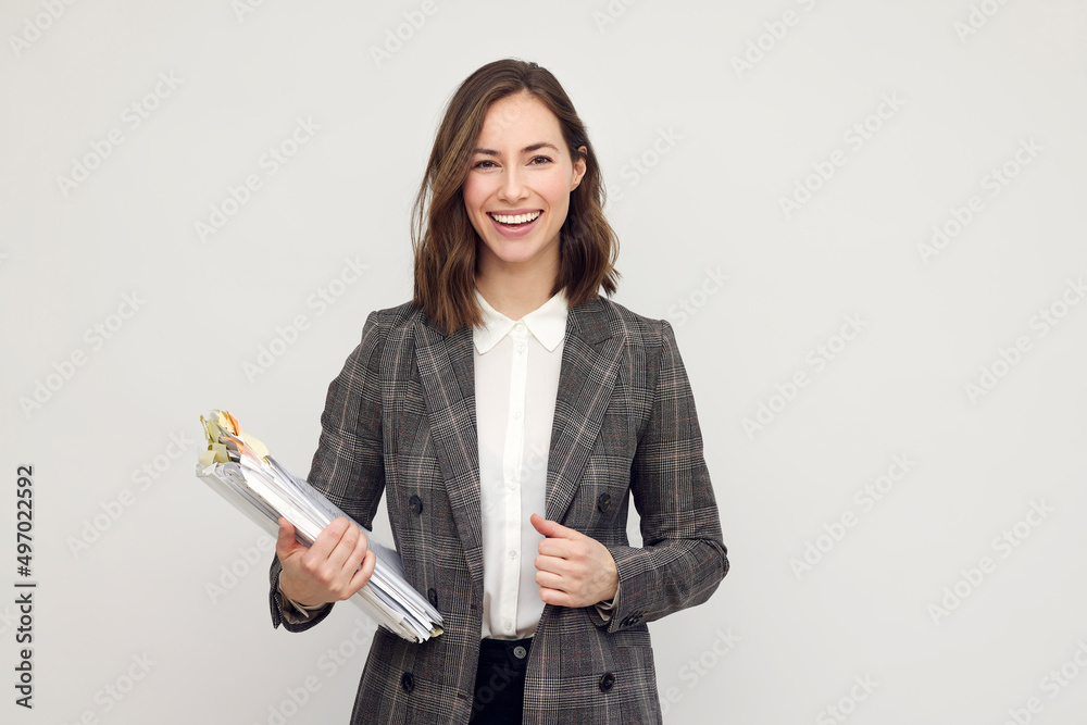 Beautiful and smiling business woman with paperwork in hand, standing ...