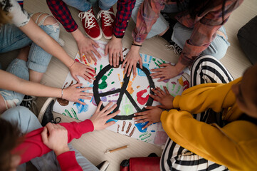 top view of students making a poster of peace sign at school.