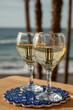 © barmalini - Glasses of Spanish dry white wine served on andalusian style board with blue ornament on beach terrace with view on Mediterranean sea