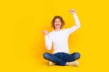 Poster - Photo of funny guy sitting floor advertising black friday bargain recommend product isolated on yellow color background