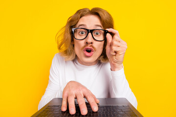 Photo of funny impressed guy dressed white shirt arm glasses writing modern device isolated yellow color background